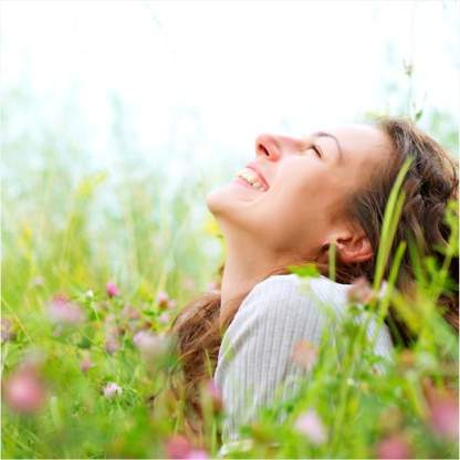 Foto de uma mulher sorrindo e olhando para o céu.
